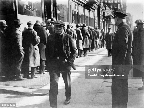 Des milliers de chômeurs attendent l'heure du repas gratuit, à la Sainte Mission à New York City, Etats-Unis en 1931.