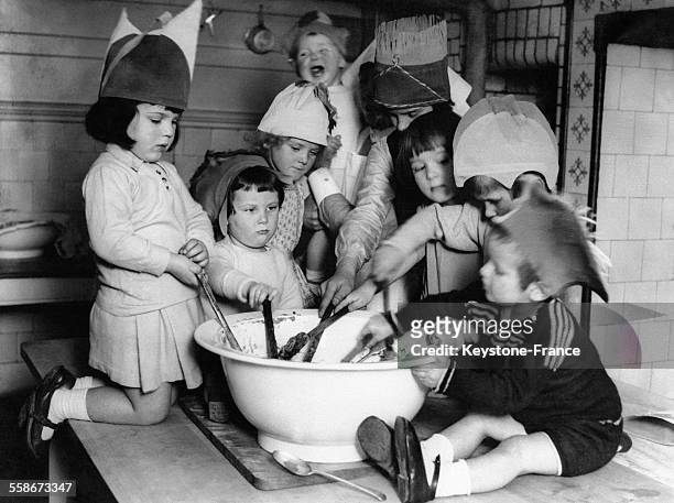 Les jeunes enfants d'un orphelinat mélangent les ingrédients du Christmas pudding dans un grand saladier le 16 décembre 1931 au Royaume-Uni.