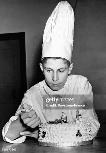 Un adolescent de 15 ans applique de la crème sur son gâteau dans le cadre d'un cours de cuisine à l'Ashmole School à Whetstone, Royaume-Uni.