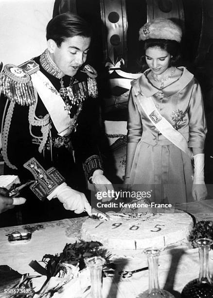 Le roi Constantin II de Grece decoupe un gateau avec sa jeune epouse la reine Anne-Marie de Grece pour feter le nouvel an, en Grece, le 4 janvier...