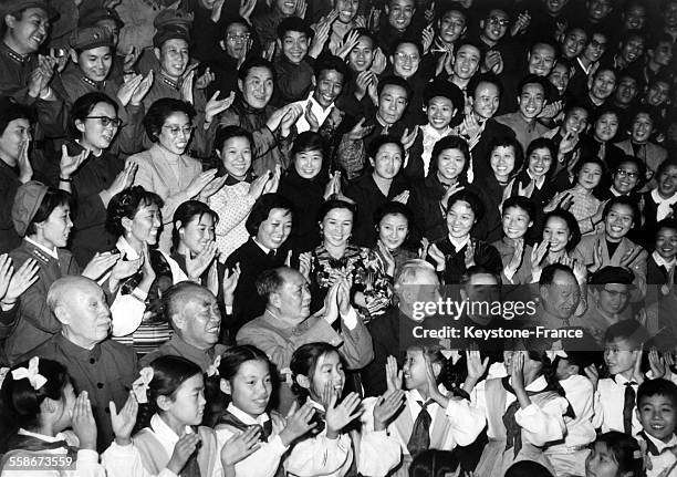 Mao Zedong et Zhou Enlai, entoures des membres du gouvernement de la Chine Populaire et de nombreux spectateurs, applaudissent la piece de théâtre...