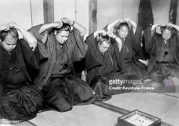 Lutteurs japonais coupant leurs chignons qu'ils étaient obligés de porter bien que la tradition se soit perdue dans le reste de la population...