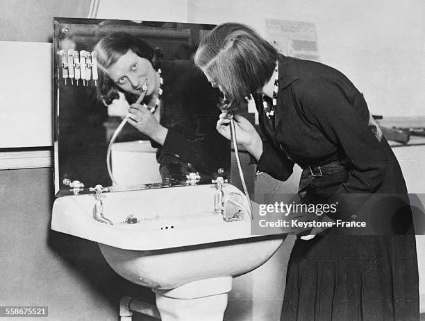 Femme se brossant les dents avec de l'eau courante en France en 1932.