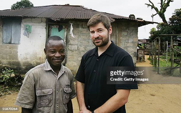 Joseph Duo a former Liberian government soldier, poses with photographer Chris Hondros at his home October 5, 2005 in Monrovia, Liberia. A picture of...