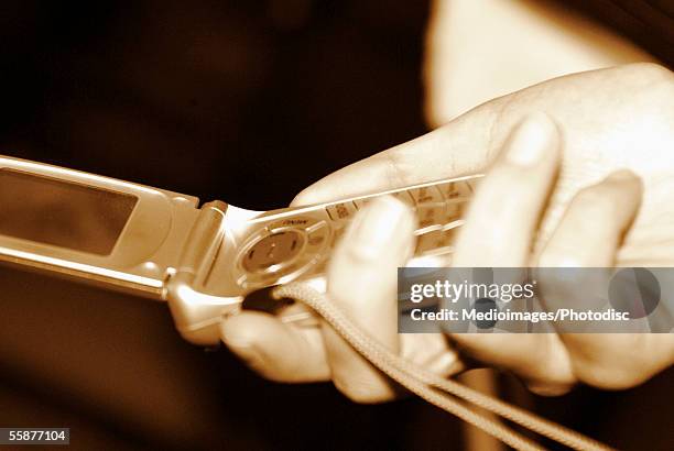 person holding and dialing cell phone - feature phone stockfoto's en -beelden