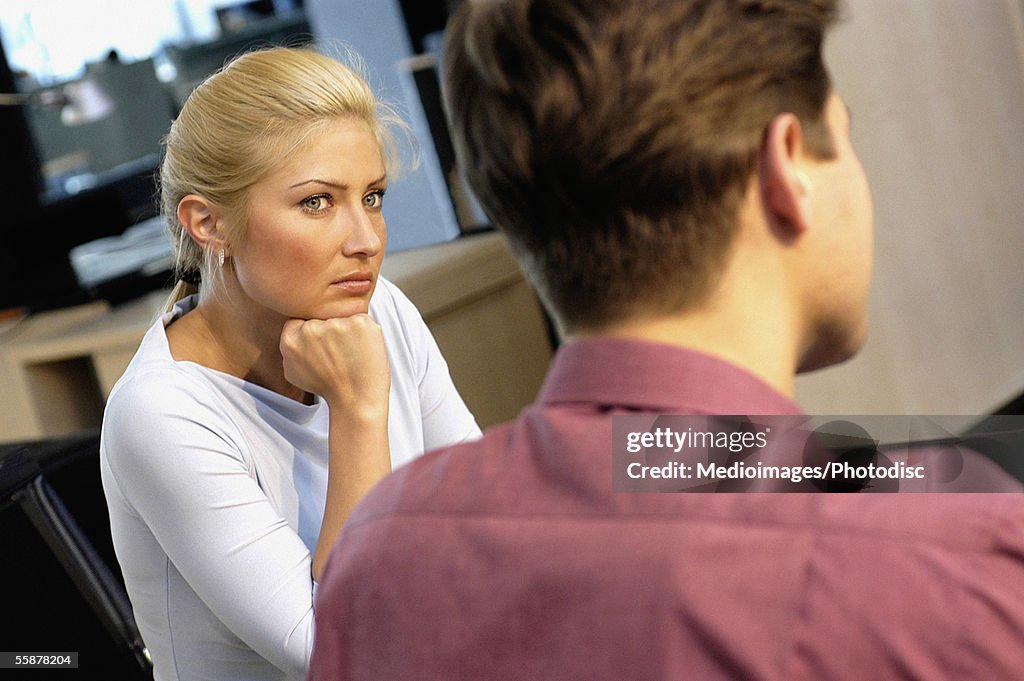 Businesswoman staring at a businessman in an office