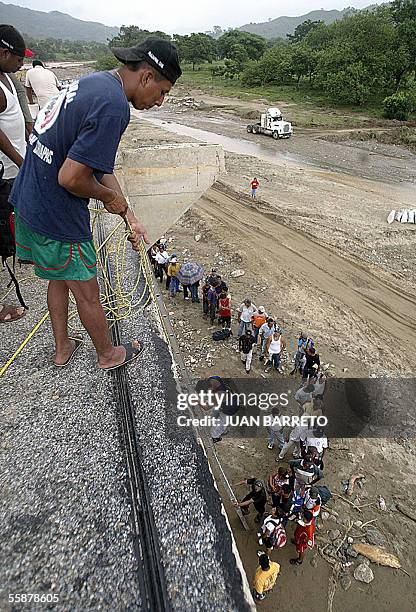 Resident of the small village of Mapastepec, some 100 km north of the border city of Tapachula, in the state of Chiapas, helps other people to climb...