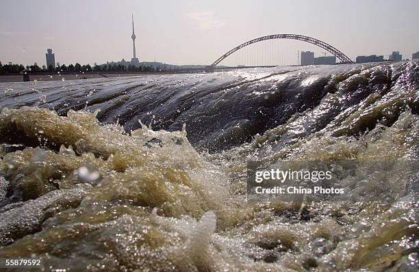 Floodwater flows at an infall where the Hanjiang River joins the Yangtze River on October 7, 2005 in Wuhan of Hubei Province, central China. Flood...