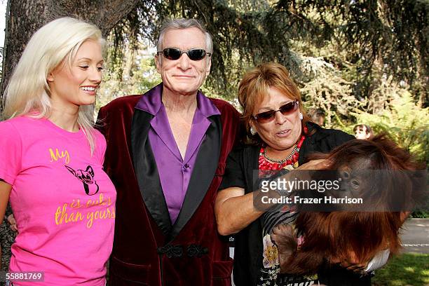 Playmate Holly Madison, Hugh Hefner and the founder and director of the Wildlife Waystation Martine Colette play with a monkey during the 11th Annual...