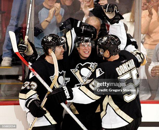 Pittsburgh Penguins Sidney Crosby is congratulated by teammates Zigmund Palffy and Sergei Gonchar after scoring his first NHL goal in the second...