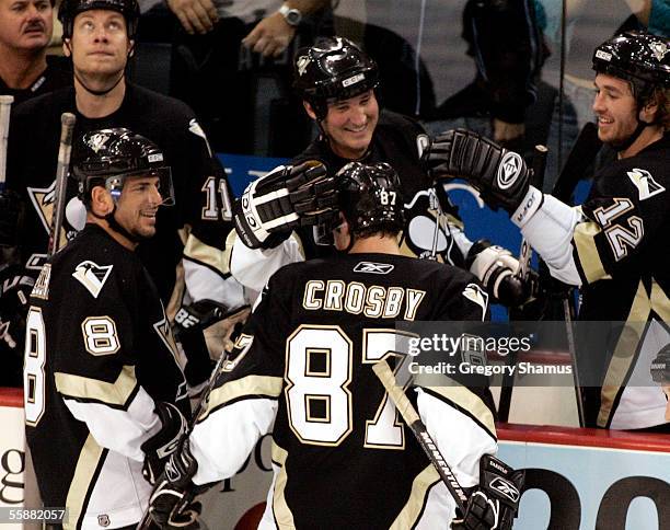 Pittsburgh Penguins Sidney Crosby is congratulated by teammates Mark Recchi, Mario Lemieux and Ryan Malone after scoring his first NHL goal in the...