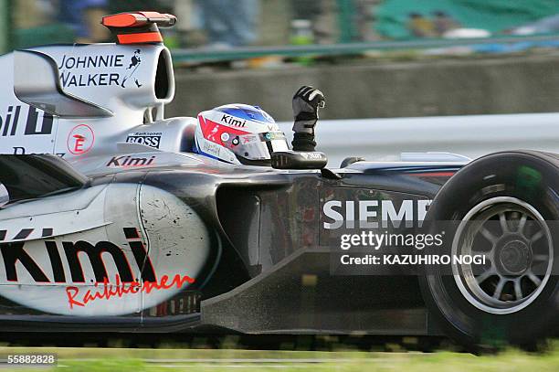 Finland's Kimi Raikkonen of McLaren Mercedes waves to the crowd during his winning run after the Japanese Grand Prix at the Suzuka circuit in central...