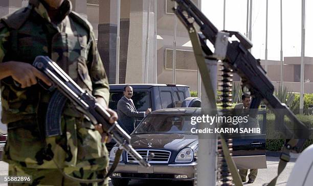 An Iraqi armed police commando guards the car of Algerian Ahmed Ben Helli , head of an Arab League as he prepares to leave a local hotel in Baghdad,...