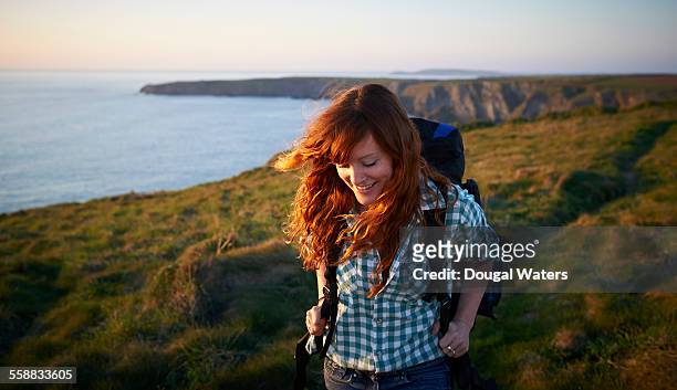 woman hiking along coastal path - hiking stock pictures, royalty-free photos & images