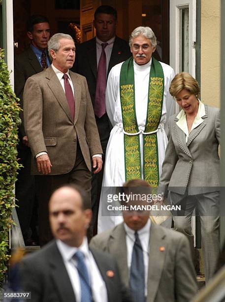 Washington, UNITED STATES: US President George W. Bush and First Lady Laura Bush are escorted by Reverend Luis Leon as they leave St. John's...