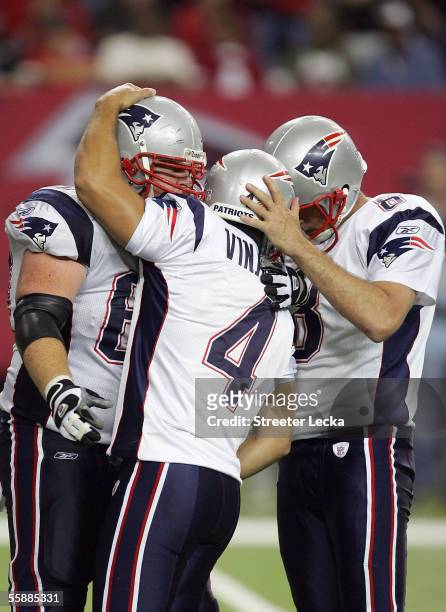 Adam Vinatieri celebrates with teammates Dan Koppen and Josh Miller of the New England Patriots after kicking the game winning field goal to defeate...