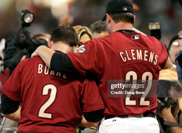 Winning pitcher Roger Clemens of the Houston Astros puts his arm around Chris Burke after Burke hit a solo home run to defeat the Atlanta Braves in...