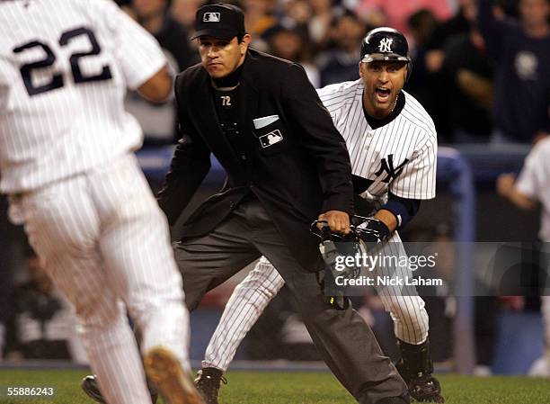 Derek Jeter of the New York Yankees screams at teammate Robinson Cano after Cano scored the tying run in the seventh inning against the Los Angeles...