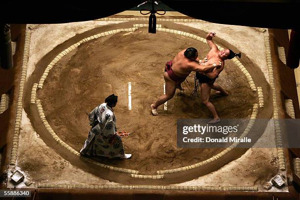 Tokitenku of Mongolia and Chiyotaikai of Japan slap each other as they wrestle under the Dohyo as the Gyoji officiates during the Grand Sumo...