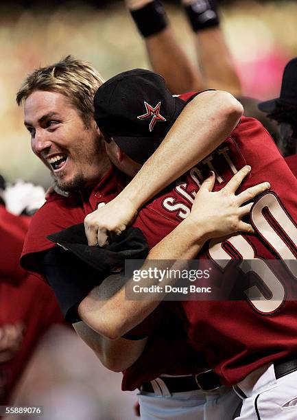 Chad Qualls and Luke Scott of the Houston Astros celebrate after Chris Burke hit a solo home run to defeat the Atlanta Braves in Game Four of the...