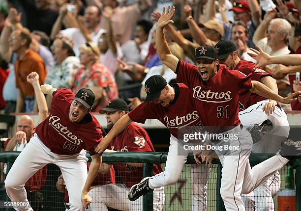 Pitcher Chad Qualls and Charles Gipson of the Houston Astros come out of the dugout to celebrate after Chris Burke hit a solo home run to defeat the...