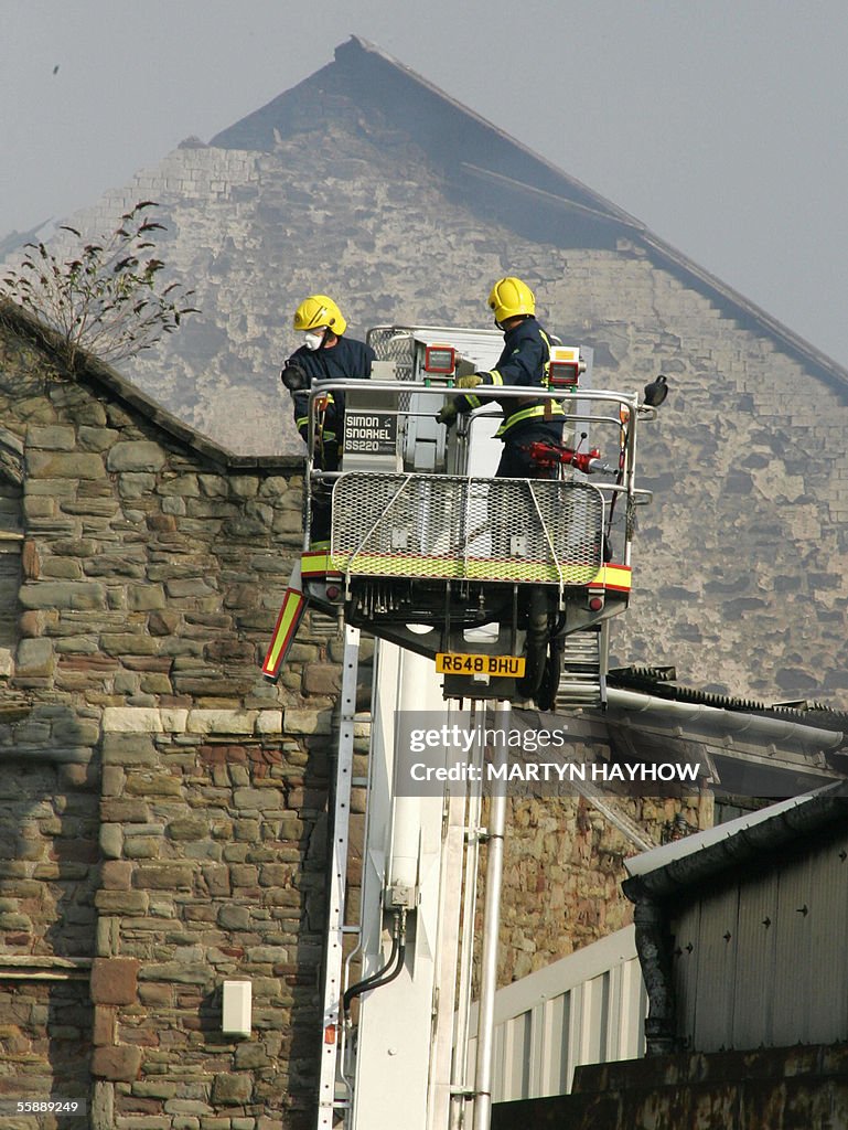 Firemen Firemen lower their fire-fighting equipment after dowsing the fire ...