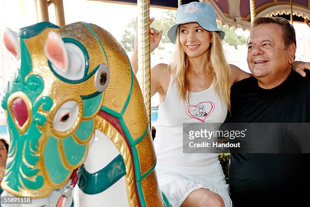In this handout photo Mira and Paul Sorvino take a ride on the Cinderella Carousel October 10, 2005 at the Magic Kingdom in Lake Buena Vista,...