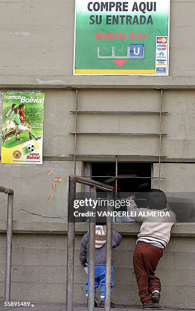 Dos ninos conversan con los vendedores de una de las boleterias del estadio Hernando Siles en La Paz el 07 de octubre de 2005, donde Bolivia y Brasil...