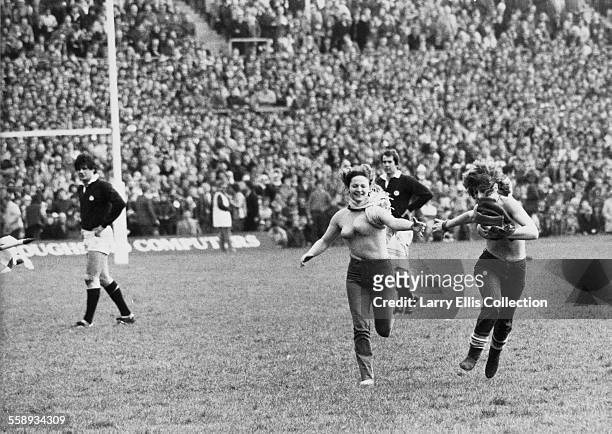Two female streakers run across the pitch at Twickenham Stadium in London, during the England v Scotland Calcutta Cup, March 1983.