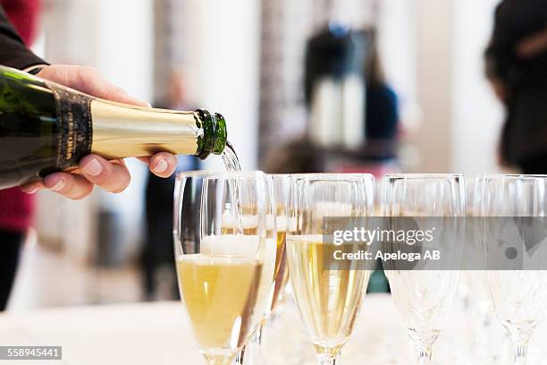 cropped image of person pouring champagne in flutes - champagnerglas stock-fotos und bilder