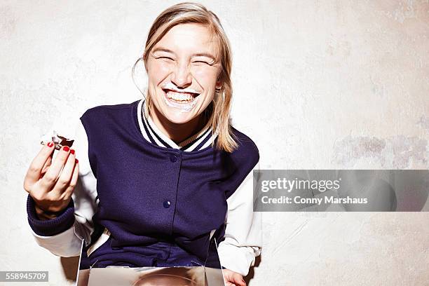 studio shot of young woman eating chocolate marshmallows - chocolate closed eyes stock-fotos und bilder