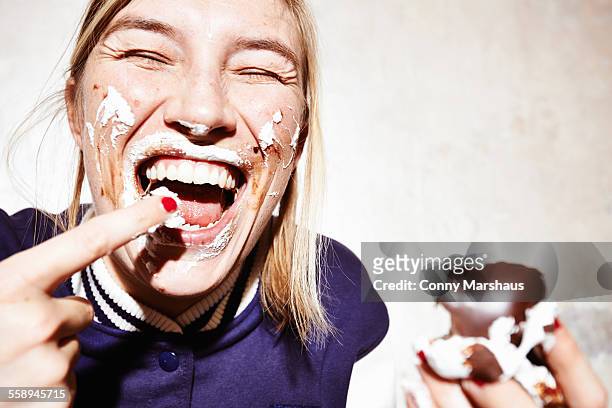close up studio shot of young woman with face covered in chocolate marshmallow - soddisfazione foto e immagini stock