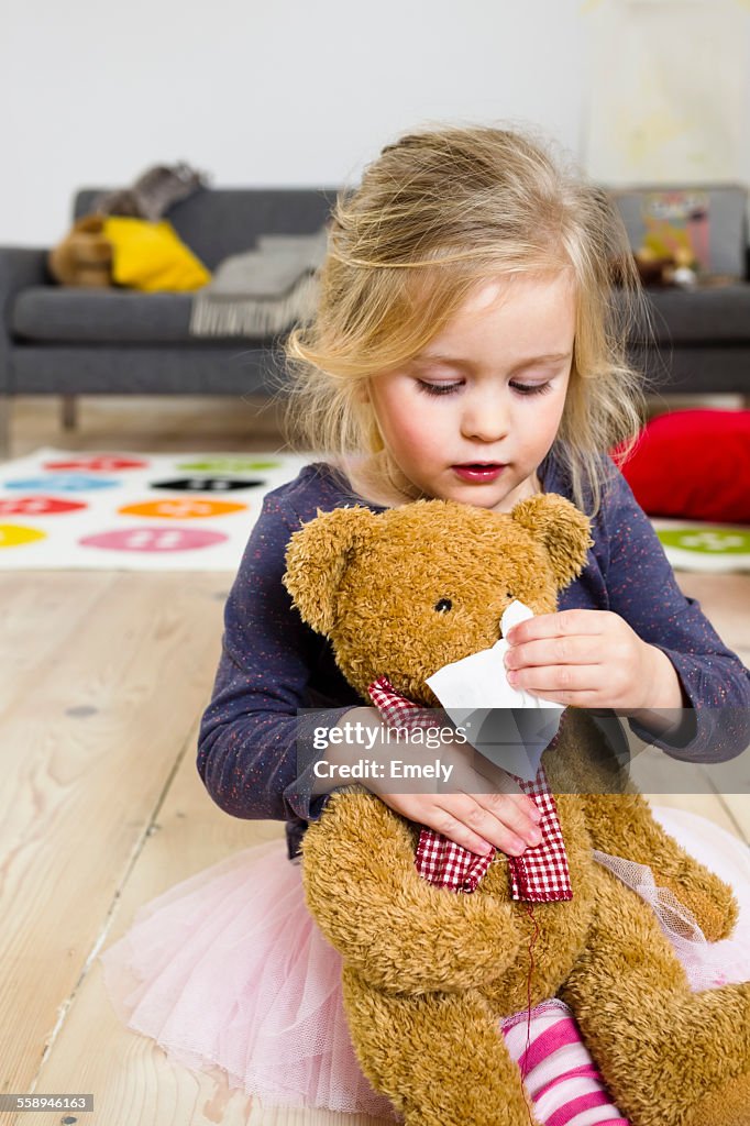 Girl playing mummy to bear