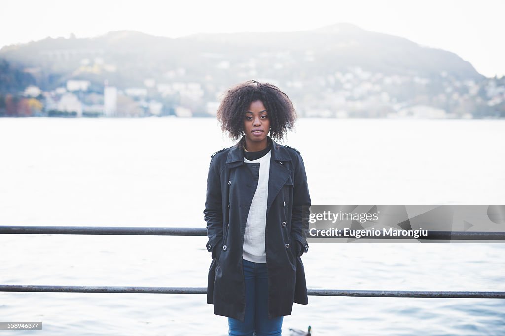 Portrait of young woman leaning against railings at Lake Como, Como, Italy