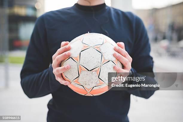 cropped shot of young man holding soccer ball - ball ストックフォトと画像