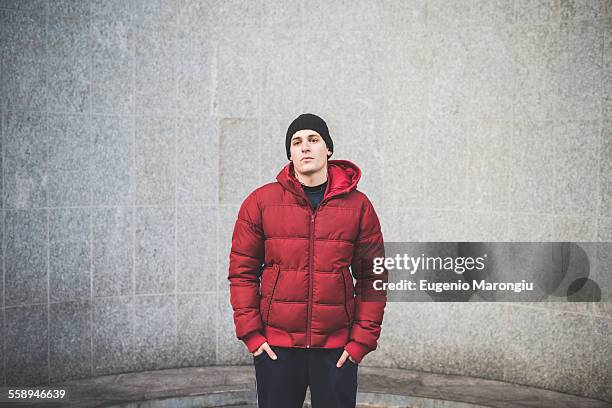 portrait of confident young man wearing red anorak - red hat imagens e fotografias de stock