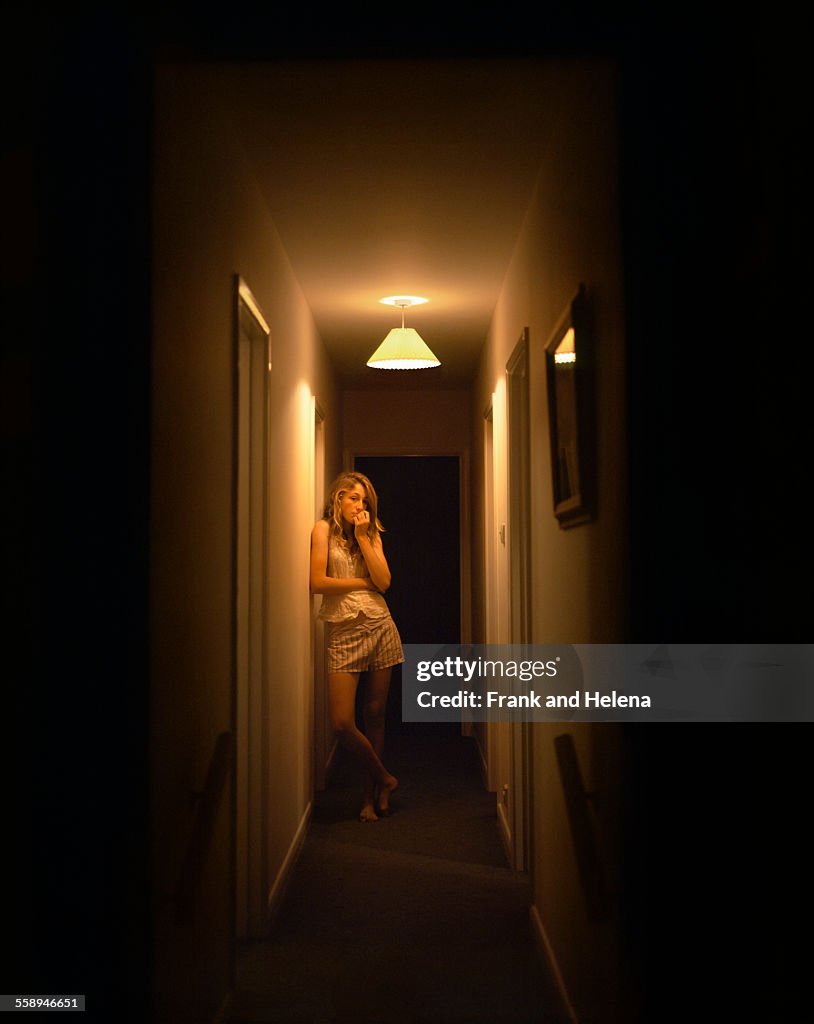 Portrait of teenage girl alone in dark corridor