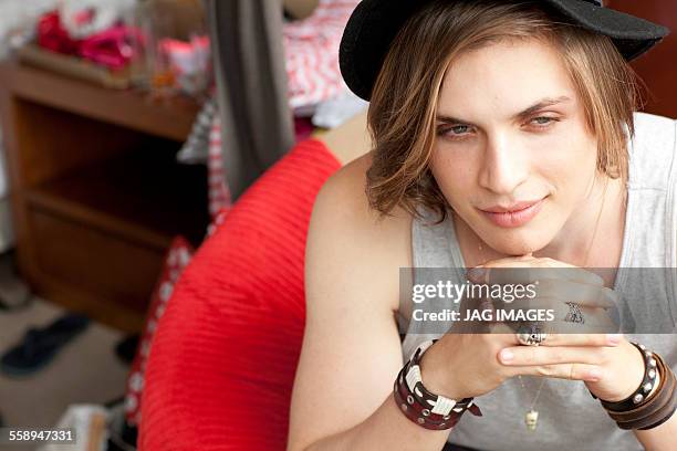 stylish young man sitting in hotel room - man fedora room stock pictures, royalty-free photos & images