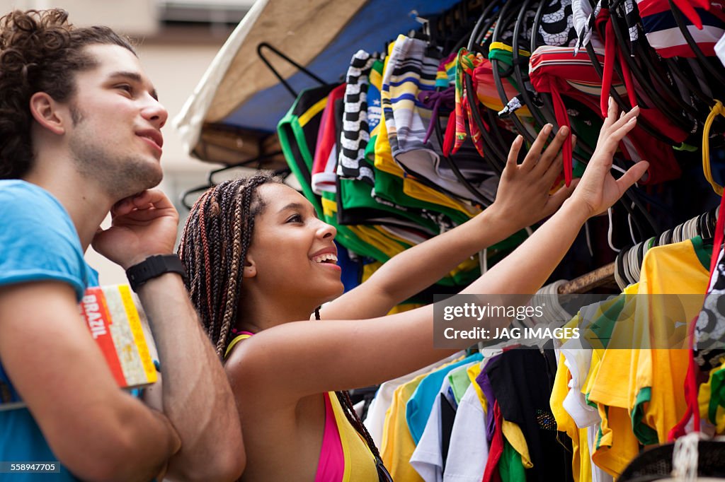 Tourist couple browsing market stall, Copacabana town, Rio De Janeiro, Brazil