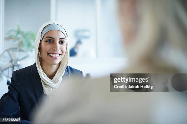 over shoulder view of young businesswoman chatting to colleague in office - female candidate stock pictures, royalty-free photos & images