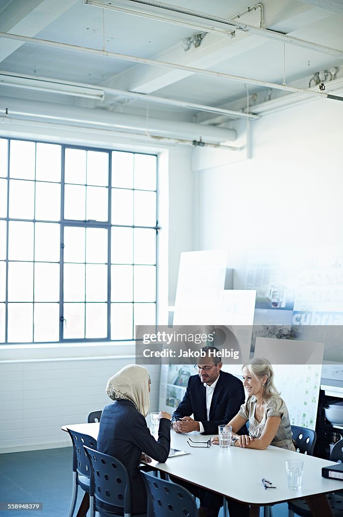 Two businesswomen and man talking at office meeting