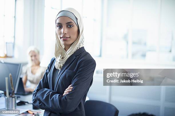 portrait of young businesswoman wearing hijab in office - woman hijab stock-fotos und bilder