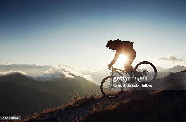 mountain biker riding downhill, valais, switzerland - mountainbiken fietsen stockfoto's en -beelden