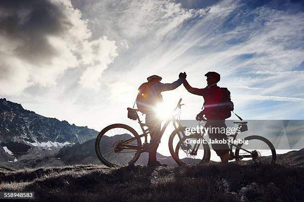 mountain bikers shaking hands, valais, switzerland - bike winning imagens e fotografias de stock
