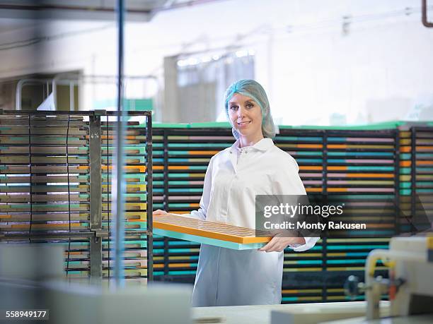 portrait of worker stacking moulds in chocolate factory - carrying food stock pictures, royalty-free photos & images
