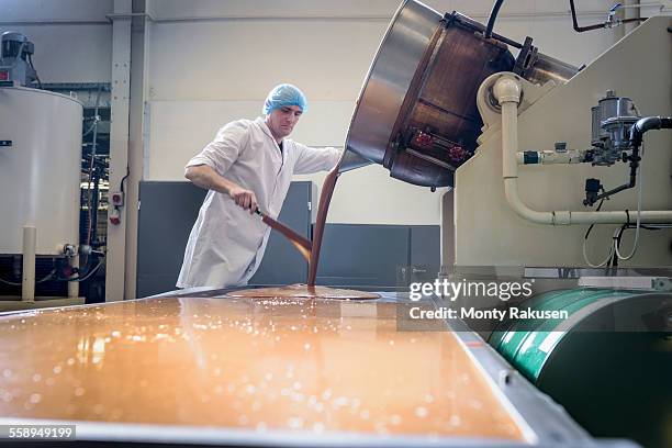 worker pouring confectionery fudge in chocolate factory - chocolate factory stockfoto's en -beelden