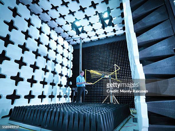 engineer checking the bilog antenna set up for electromagnetic compatibility (emc) radiated emissions in anechoic chamber with energy absorbers - surface preparation stock pictures, royalty-free photos & images