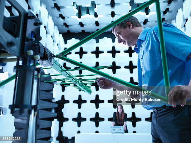 engineers checking a bilog antenna for electromagnetic compatibility (emc) radiated immunity testing in a semi anechoic chamber relative to the electronic equipment under test (eut) - anechoic chamber stock pictures, royalty-free photos & images