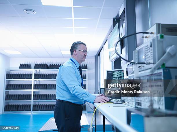 electromagnetic compatibility engineer carrying out radiated emissions scan on electrical equipment in anechoic chamber using high performance power supply and network analyser - anechoic chamber stock pictures, royalty-free photos & images