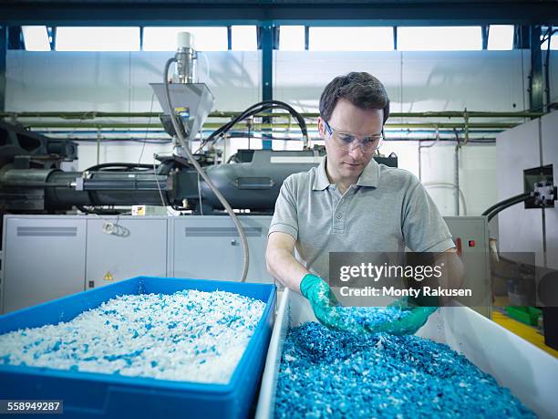 worker inspecting recycled plastic in plastics factory - recycling fotografías e imágenes de stock